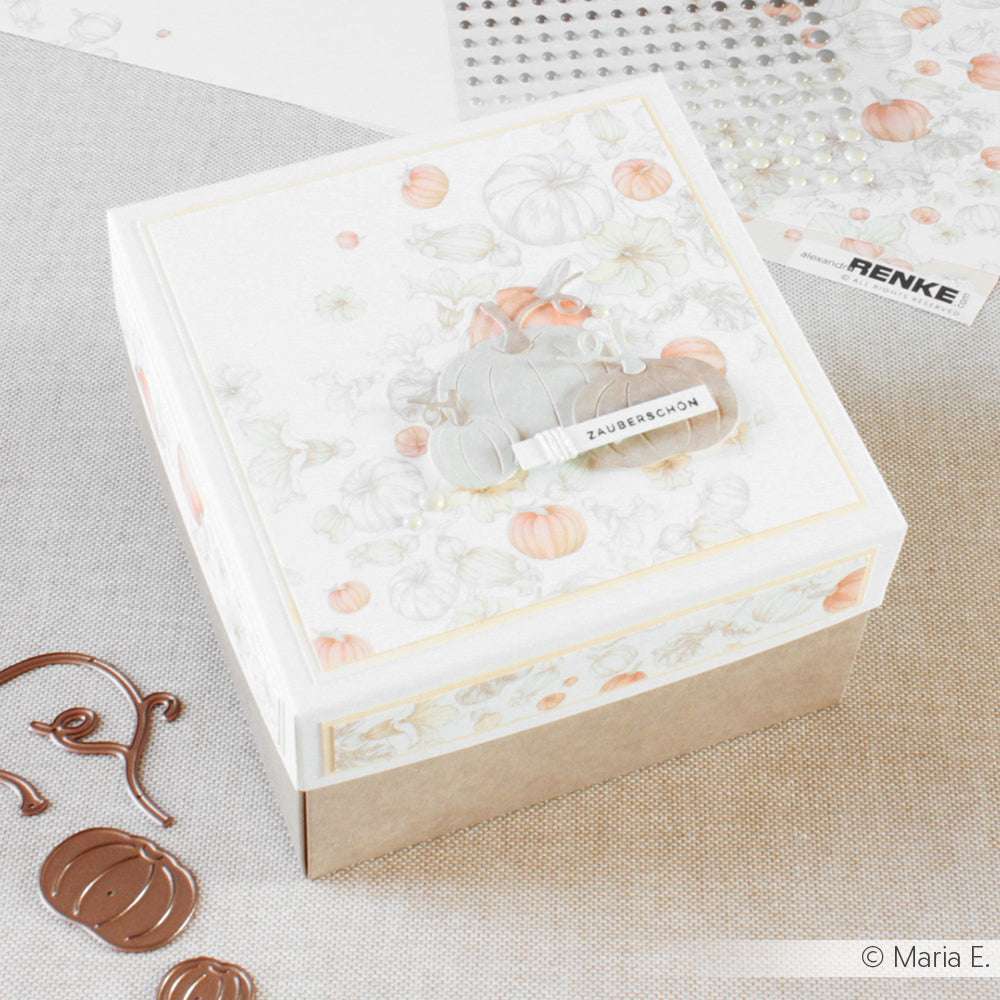 Eine dekorative Schachtel von Alexandra Renke aus Designpapier mit Kürbismuster und einer Zauberschön-Tube - ideal für kreative Papierprojekte.