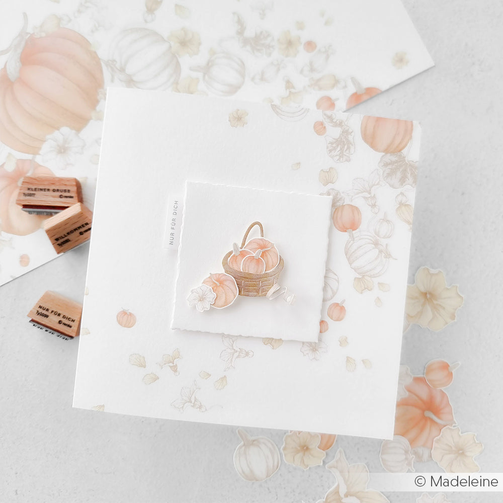 Eine Grußkarte von Alexandra Renke mit zart pastellfarbenen Kürbis-Illustrationen und einem Korb voller Kürbisse in der Mitte - ideal für Fans des einzigartigen Designpapier-Stils.