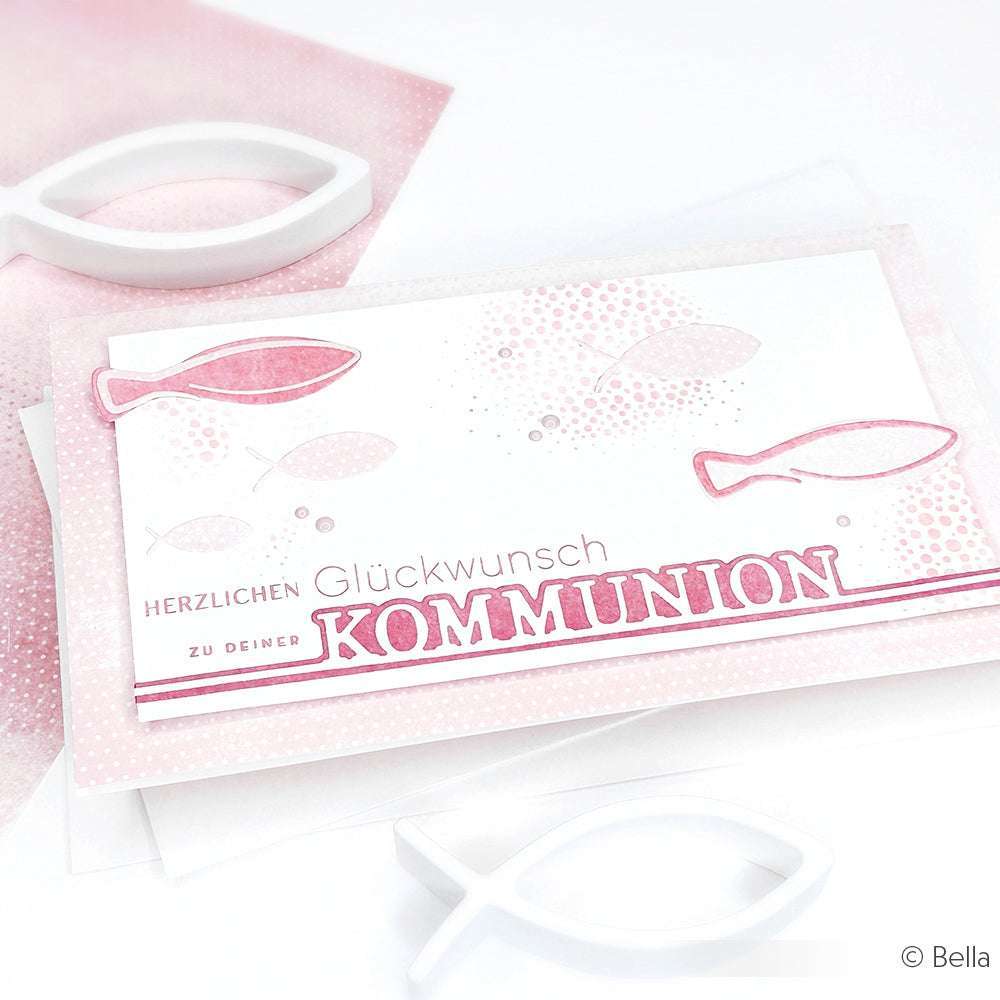 Die rosa-weiße Kommunionskarte von Alexandra Renke, hergestellt mit Designpapier, zeigt Fischmotive und den deutschen Text "Herzlichen Glückwunsch zur KOMMUNION".