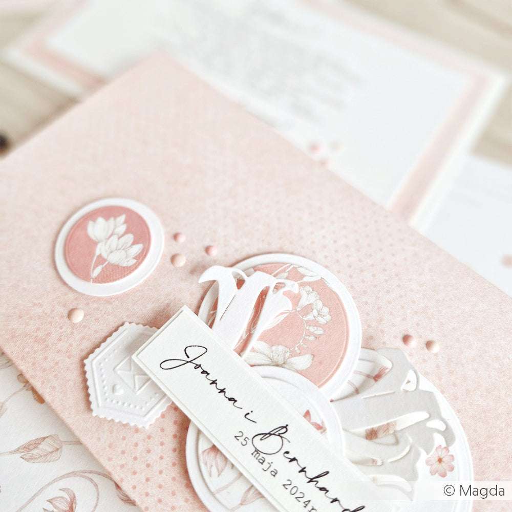 Nahaufnahme einer mit Alexandra Renke Designpapier gestalteten Hochzeitseinladung mit rosa und weißen Blumen, zarten Ausschnitten und elegantem Text in Schreibschrift.