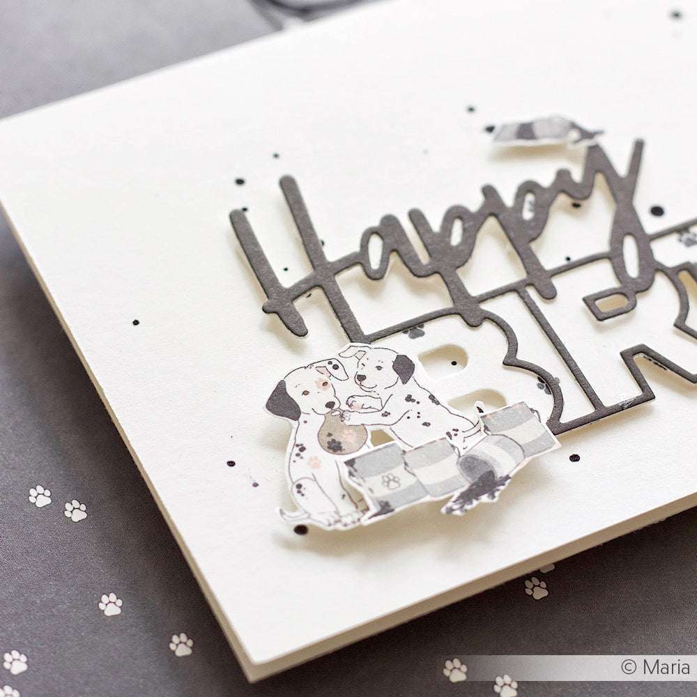 Nahaufnahme einer Karte von Alexandra Renke mit "Happy"-Text und zwei illustrierten Dalmatinern auf weißem Designpapier, verspielte Pfotenabdrücke im Hintergrund - ideal für kreative Papierprojekte.