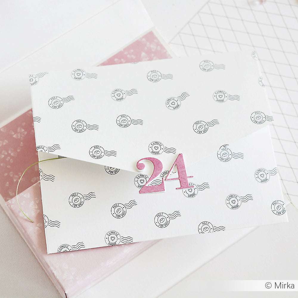 Ein weißer Umschlag von Alexandra Renke mit Briefmarkenmotiven und einer rosafarbenen 24 auf der Klappe liegt auf pastellfarbenem Designpapier - ideal für Grußkarten oder Papierprojekte.
