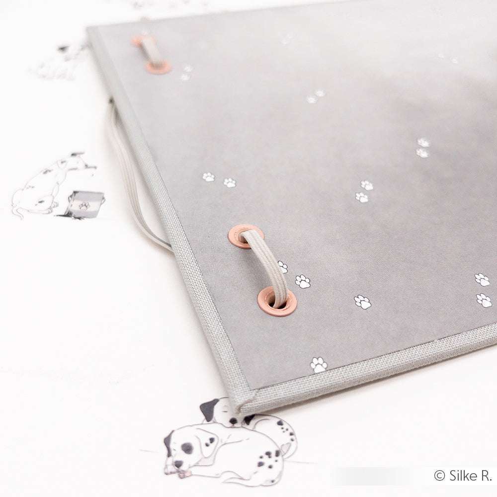 Graue Mappe von Alexandra Renke mit Schnurverschluss aus hochwertigem Designpapier, verziert mit kleinen Pfotenabdrücken und Dalmatiner-Illustrationen auf weißem Hintergrund.