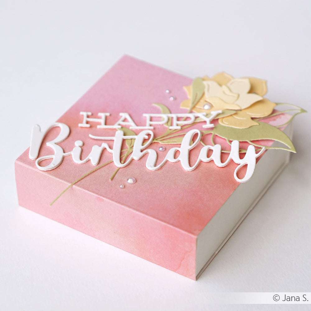Elegante rosafarbene Geschenkbox von Alexandra Renke mit "Happy Birthday"-Schriftzug und gelber Blume auf dem Deckel, gefertigt aus hochwertigem Designpapier - ideal für einzigartige Papierprojekte oder als besonderes Buchbinderei-Geschenk.