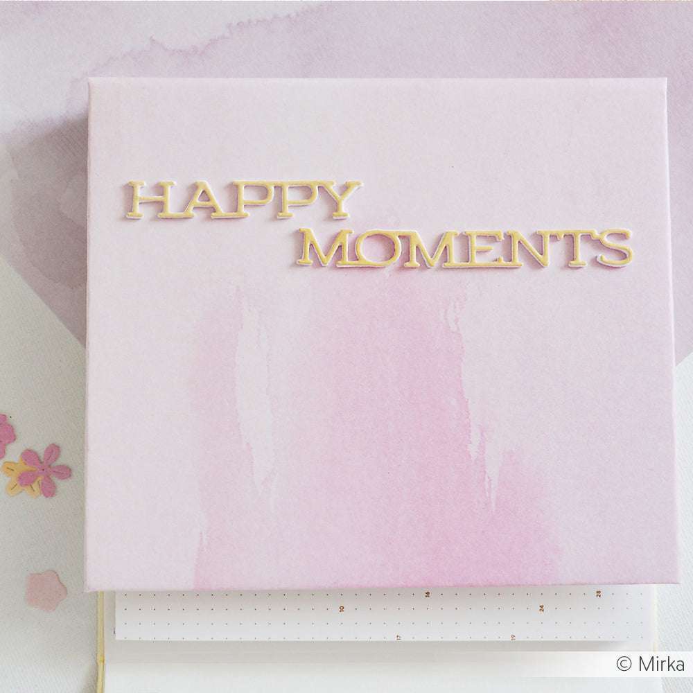 Das Scrapbook-Cover von Alexandra Renke zeigt einen hellrosa Rosa-Pink-Verlauf mit goldenem Schriftzug "HAPPY MOMENTS" - ideal für Ihre Papierprojekte.