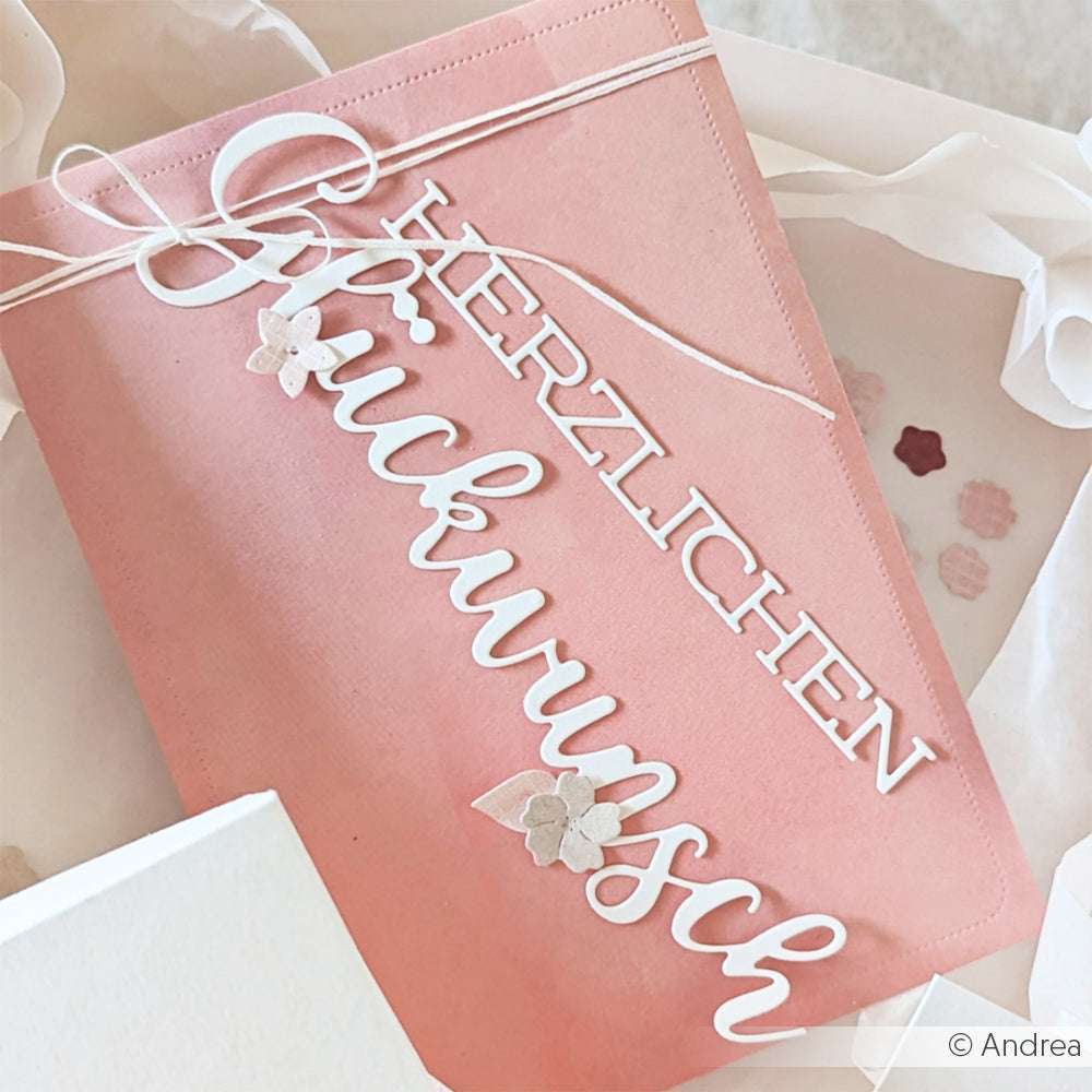 Rosa Karte von Alexandra Renke mit weißem "Herzlichen Glückwunsch"-Schriftzug und einer kleinen Blume oben drauf - ideal für Papierprojekte oder als einzigartiges Designpapier in der Buchbinderei.