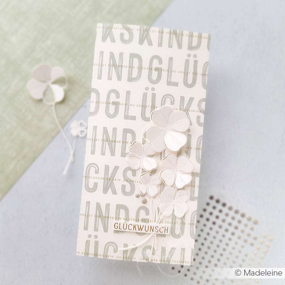 Rechteckige Karte mit deutschem Text und weißen Papierklee-Akzenten; GLÜCKWUNSCH sticht hervor - eine schöne Kreation von Alexandra Renke, die mit exquisitem Designpapier aufwartet.