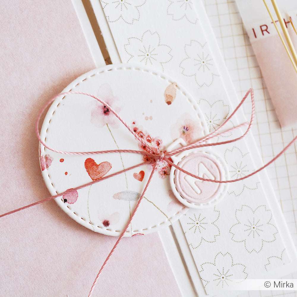 Runde Blumenkarte mit rosafarbener Kordel und Wachssiegel, gefasst auf zartem Designpapier und einem floral gemusterten Streifen - perfekt für Papierprojekte oder elegante Buchbinderei von Alexandra Renke.