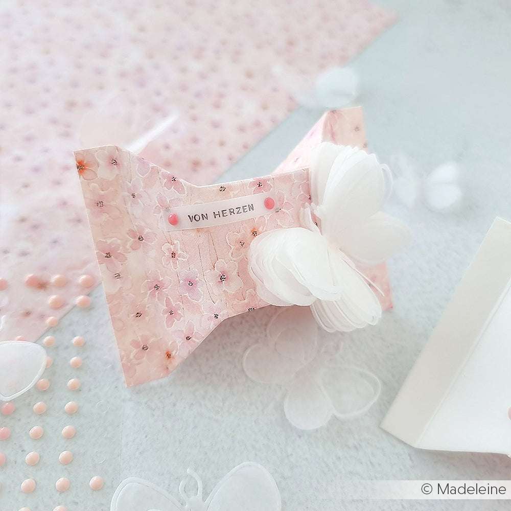 Pinkfarbene Karte in Schmetterlingsform aus dem floralen Designpapier von Alexandra Renke mit dem Text "von Herzen" und einem zarten weißen Schmetterling in Lagen - perfekt für kreative Papierprojekte.