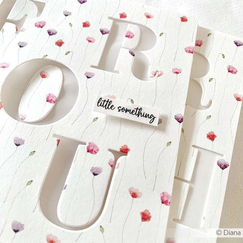 Weiße Karten mit großen ausgeschnittenen Buchstaben, kleinen floralen Mustern und einer "Kleinigkeit" als Etikett - gebastelt aus Alexandra Renke Designpapier Feine Mohnblüten. Perfekt für kreative Papierprojekte.
