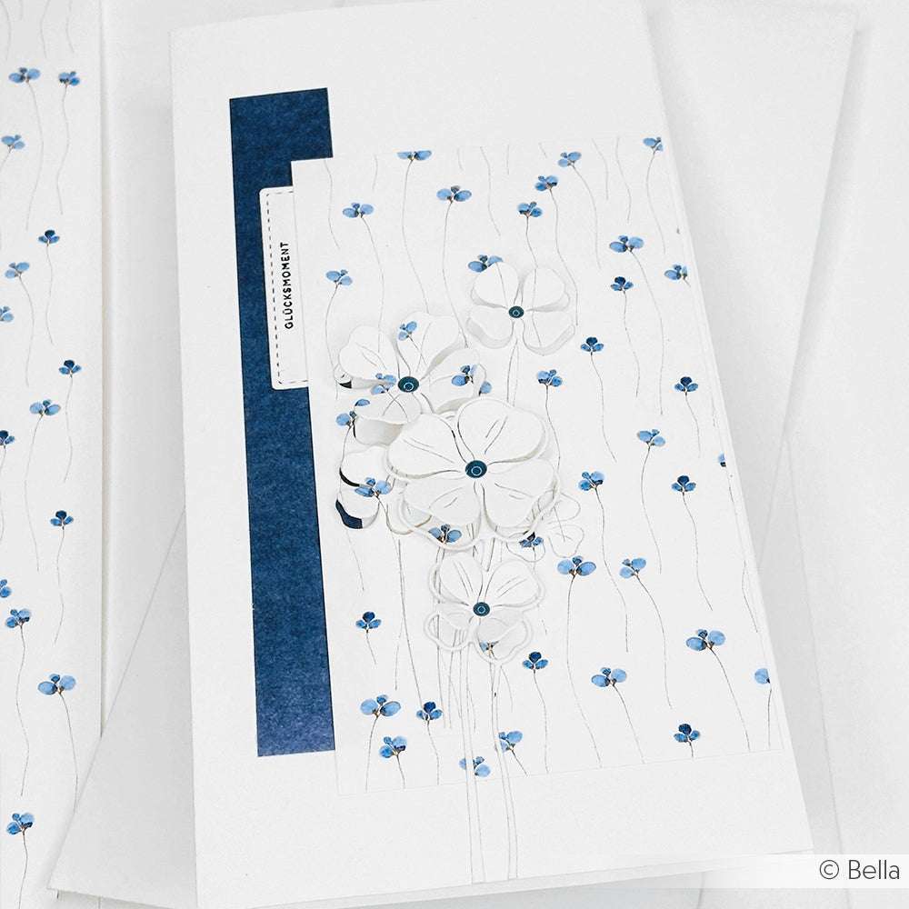 Weiße Grußkarte von Alexandra Renke mit blauen Akzenten, geprägten weißen Blumen und zarten blauen Blumenmustern - ideal für Ihre Papierprojekte oder in Kombination mit Ihrem Lieblingsdesignpapier.
