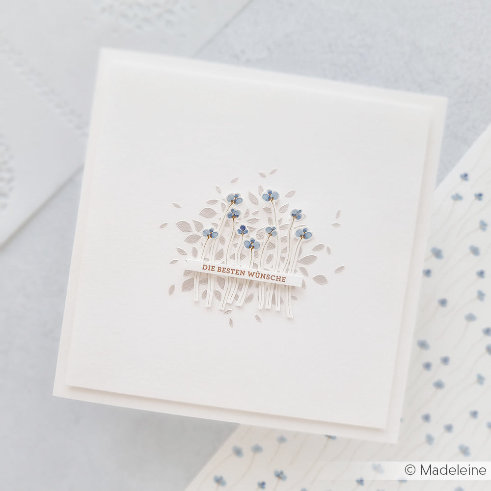 Quadratische weiße Karte von Alexandra Renke mit zarten blauen Blüten und dem Text "DIE BESTEN WÜNSCHE" in der Mitte - perfekt für kreative Papierprojekte oder als einzigartiges Designerpapier.