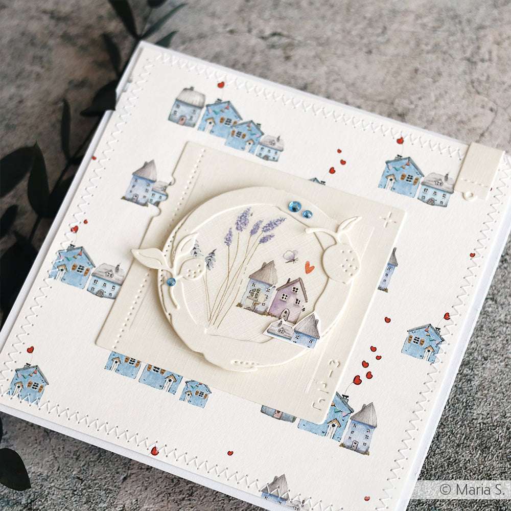 Handgefertigte Karte von Alexandra Renke, hergestellt aus Designpapier mit blauen Hausillustrationen und einem kreisförmigen Motiv mit Blumen und kleinen Herzen - ideal für einzigartige Papierprojekte und kreative Geschenke.