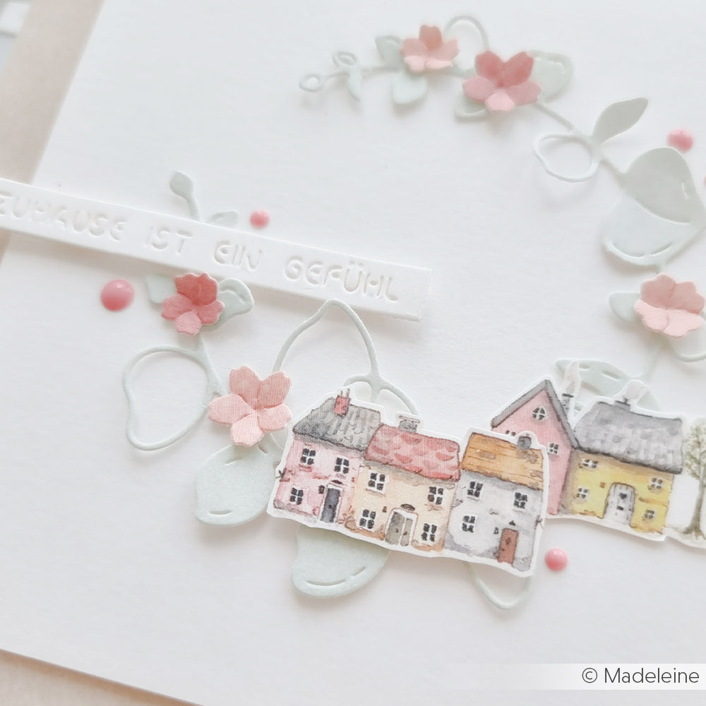 Handgemachte Karte von Alexandra Renke mit pastellfarbenen Papierblumen, kleinen gemalten Häusern und deutschem Text auf weißem Hintergrund - ideal für Papierprojekte oder mit einzigartigem Designpapier gestaltet.