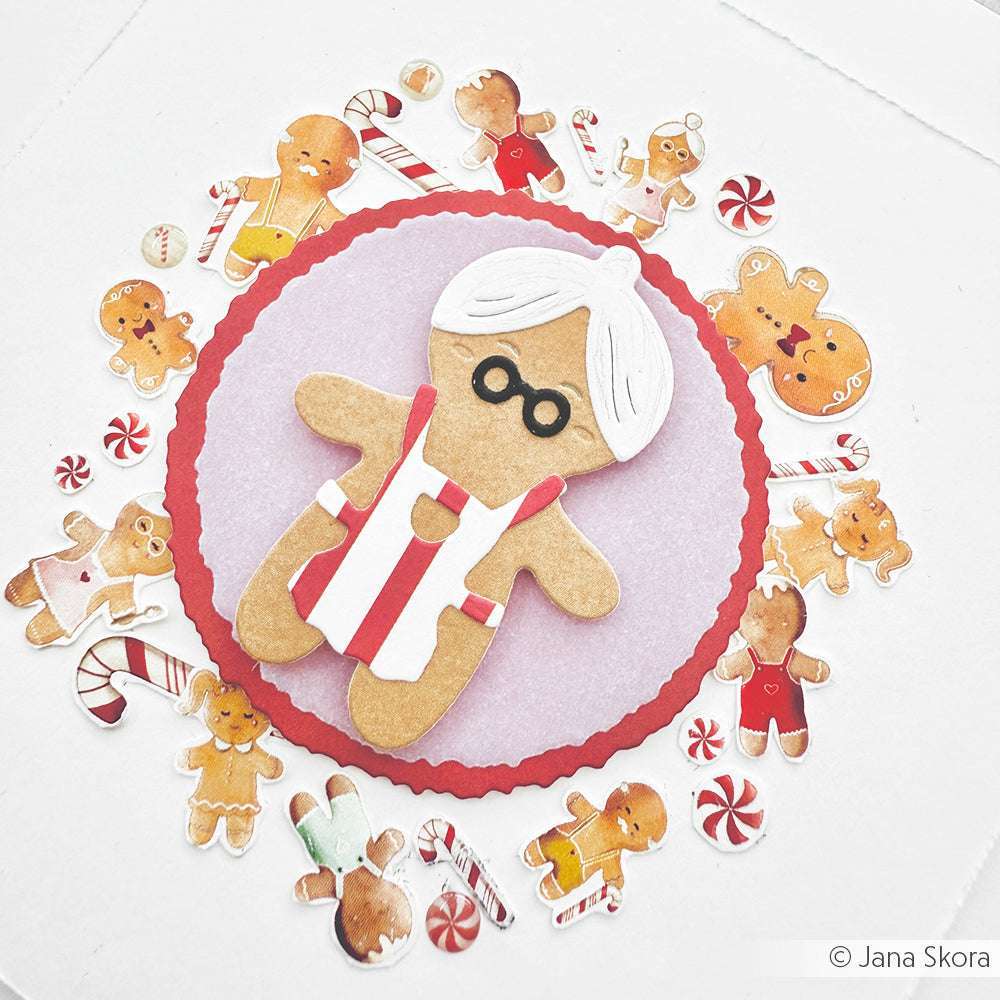 Ein Lebkuchen-Oma-Keks auf einem roten Kreis, umgeben von Lebkuchen- und Süßigkeiten-Illustrationen - perfekt für Grußkarten oder Papierprojekte mit festlichem Designerpapier von Alexandra Renke.