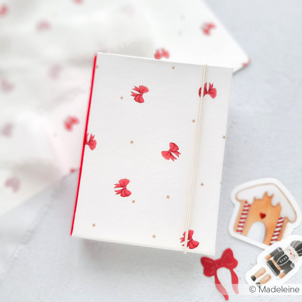 Weiße Schachtel von Alexandra Renke mit roten Schleifen, goldenen Sternen und Kordel - gepaart mit Lebkuchen- und Schleifenaufklebern - ideal für Papierprojekte oder zur Veredelung Ihrer Buchbinderei-Kreationen.