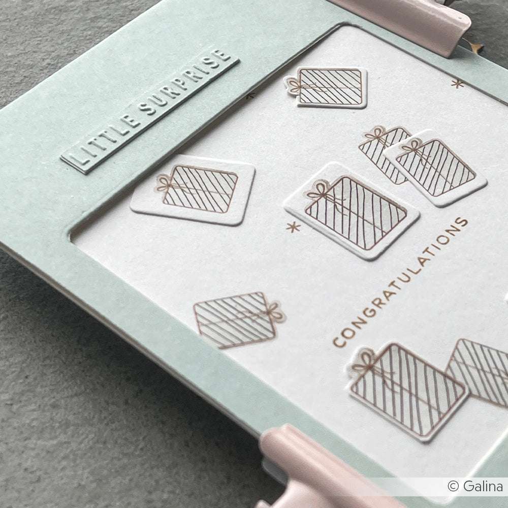 Eine Alexandra Renke Grußkarte mit Geschenkillustrationen und goldenen Texten LITTLE SURPRISE und CONGRATULATIONS, gefertigt aus hochwertigem Designpapier.