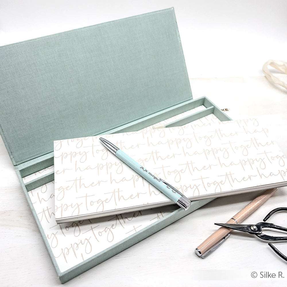 Hellblaue Alexandra Renke Schreibwarenbox mit Zetteln, einem blauen Kugelschreiber, einem hellen Bleistift und einer Schere - ideal für Papierprojekte oder zur Erweiterung Ihrer Buchbinderei-Sammlung.