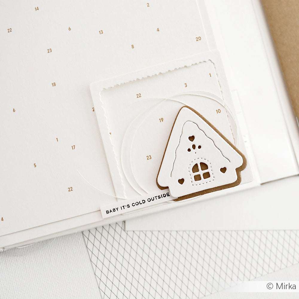 Ein Lebkuchenhaus aus Papier von Alexandra Renke Designpapier schmückt ein minimalistisches Kalenderblatt mit der Aufschrift "Baby it's cold outside", perfekt für festliche Papierprojekte.