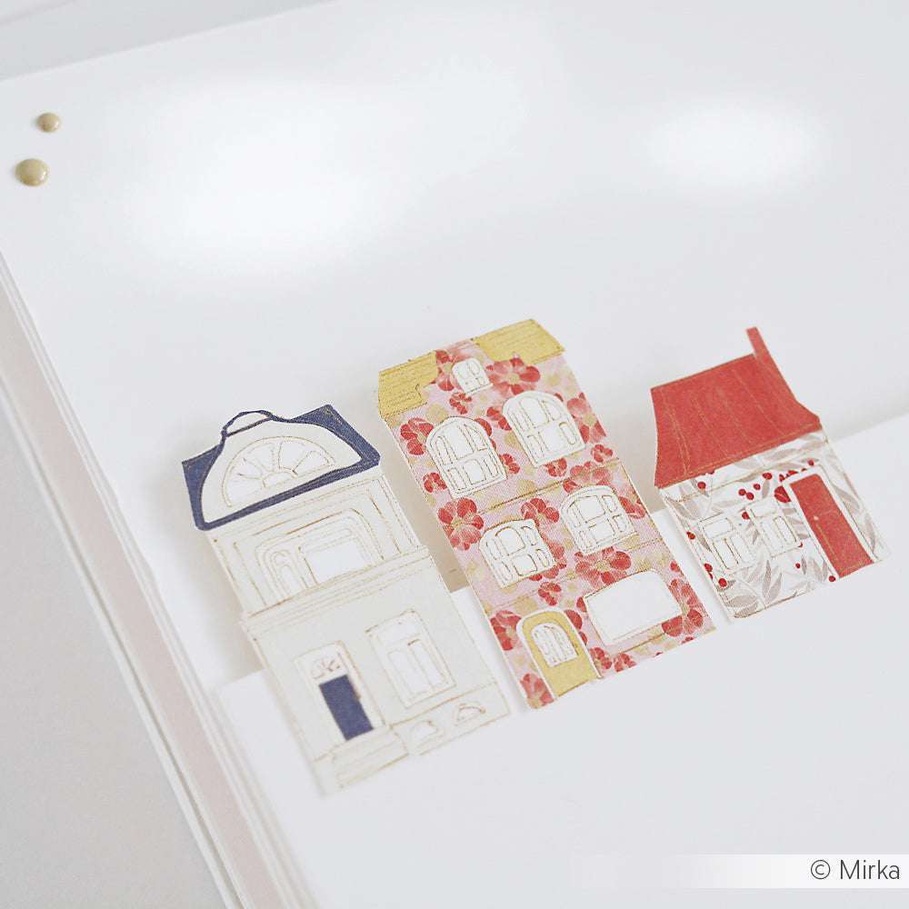 Drei kleine Papierhäuschen mit einzigartigen Mustern und Farben, hergestellt aus lebendigem Alexandra Renke Designpapier, sind auf einer weißen Fläche angeordnet.