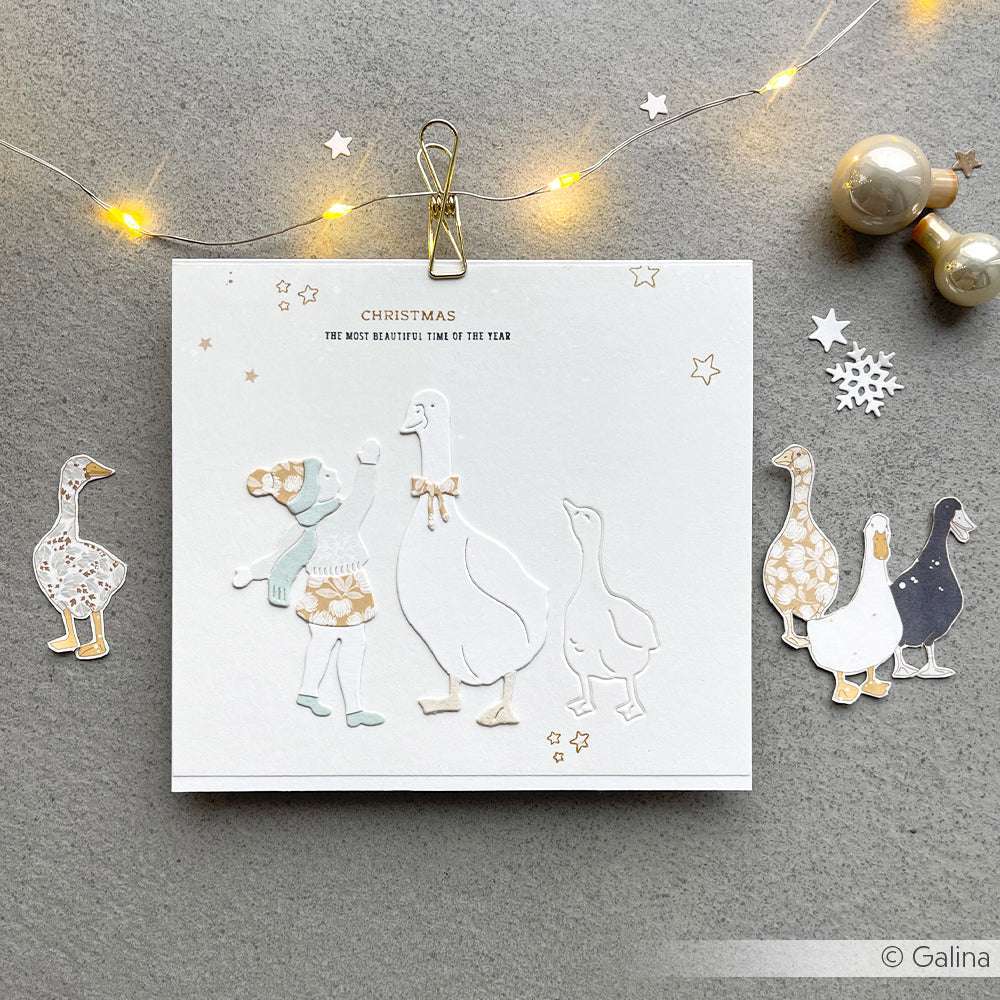 Handgemachte Weihnachtskarte von Alexandra Renke mit einem ausgeschnittenen Mädchen und Gänsen, gefertigt aus gemustertem Papier mit Papiergänsen und festlichen Lichtern - perfekt für charmante Papierprojekte.