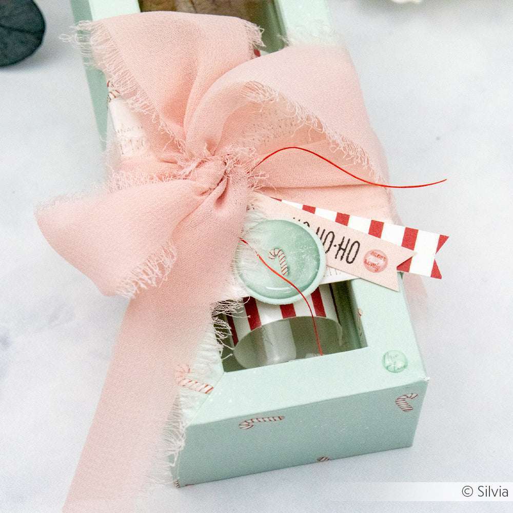 Pastellgrüne Geschenkbox mit rosa Schleife, Wachssiegel und gestreiften Anhängern, verziert mit Alexandra Renke Zuckerstangen-Gewusel Mint Designpapier für charmante Papierprojekte.