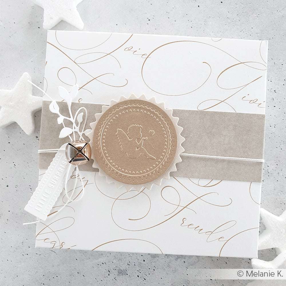 Quadratische weiße Karte mit beigem Engelssiegel, Schrift in Typo Freude International Gold, weißen Blättern, Anhänger und silberner Glocke - perfekt für Papierprojekte oder Designpapier-Kreationen von Alexandra Renke.