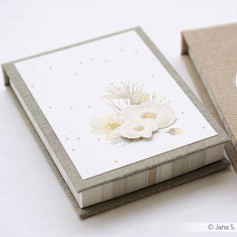 Eine dekorative Schachtel von Alexandra Renke mit floralem Designpapier auf dem Deckel, mit weißen und gelben Blumen und sanften beigen Akzenten - perfekt für Papierprojekte oder zum Verschenken.