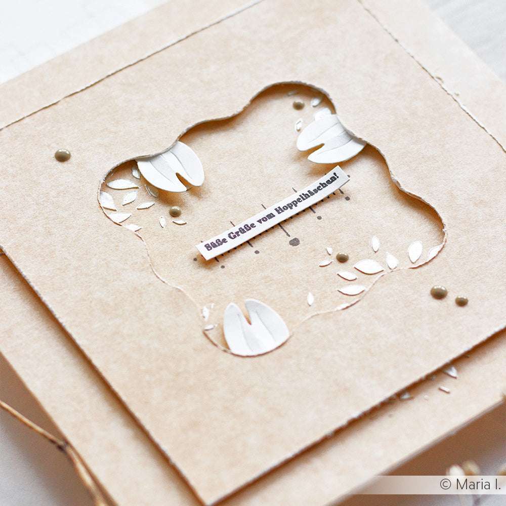 Eine handgefertigte Karte von Alexandra Renke mit ausgestanzten Hasenohren und einem deutschen Gruß, hergestellt auf braunem Strukturpapier.