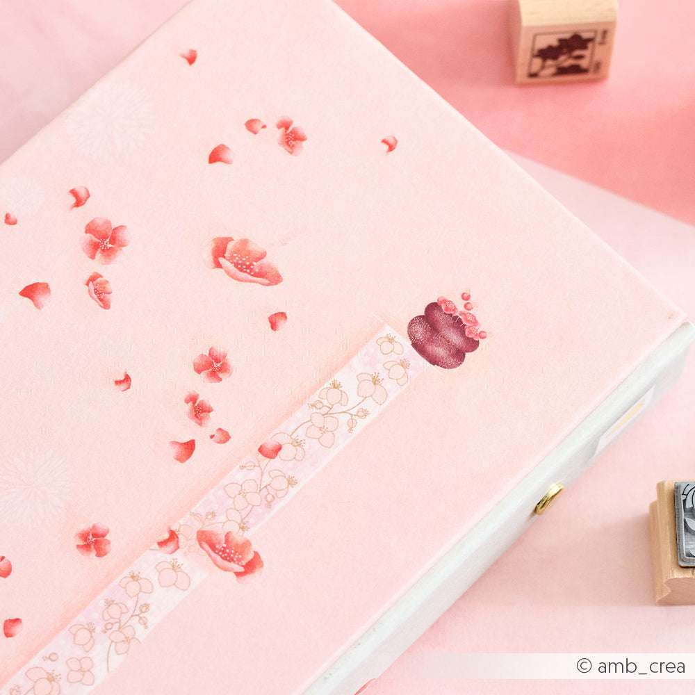 Die rosa Box von Alexandra Renke zeigt Kirschblütenmotive und einen floral gemusterten Streifen auf Designpapier, perfekt für Papierprojekte oder stilvolle Grußkarten, vor einem pastellrosa Hintergrund.