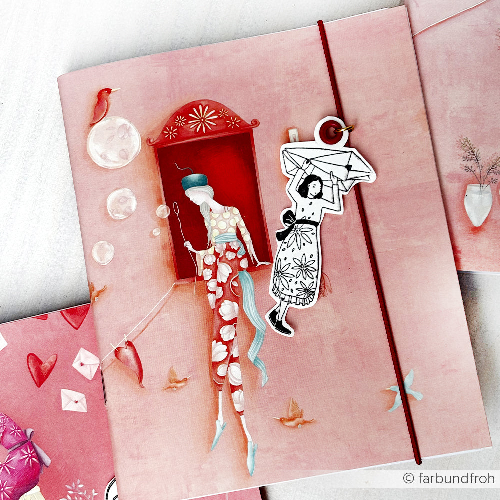 Das von Alexandra Renke illustrierte rosafarbene Notizbuch zeigt eine skurrile Frau und ein Mädchen inmitten von verträumten, surrealen Elementen - ideal für Papierprojekte oder zur Kombination mit unverwechselbaren Grußkarten.