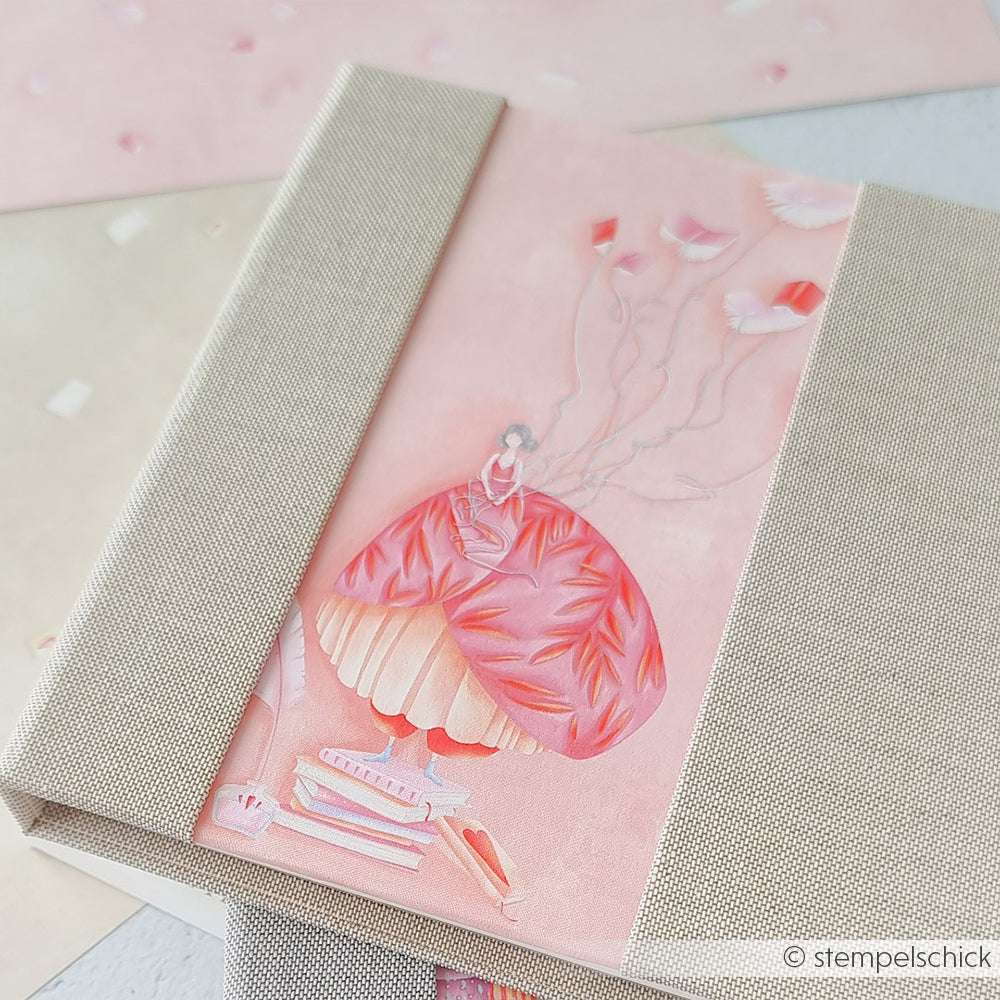 Ein Notizbuch von Alexandra Renke mit einem Einband von Lisas Figurinen Bücherzauber: ein Mädchen in einem rosa Kleid, das Blumenballons hält, umgeben von Büchern - eine charmante Auswahl für Ihre Papierprojekte und Designpapier-Ideen.