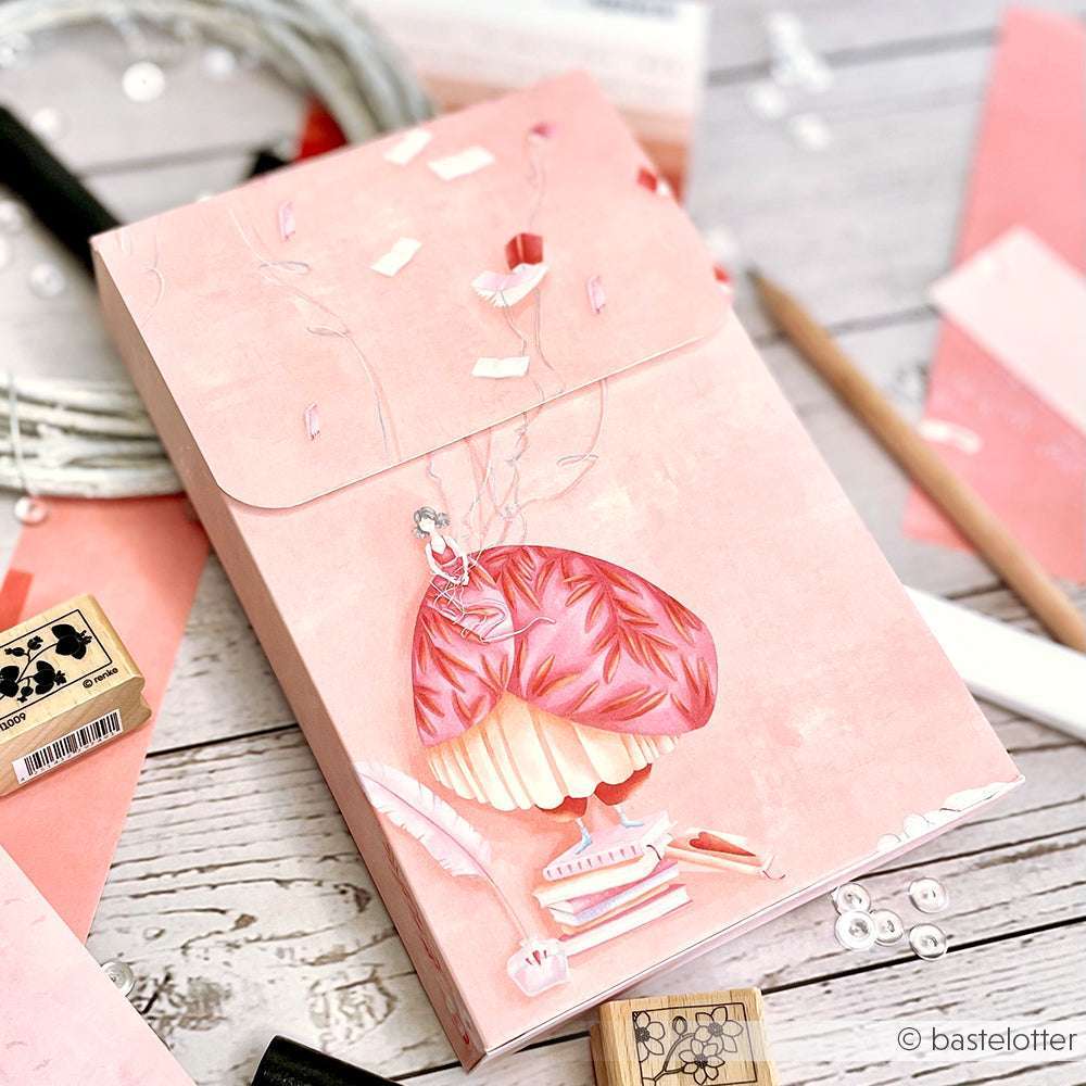 Rosa Umschlag mit einer skurrilen Mädchenillustration, umgeben von Alexandra Renke Briefpapier, Stempeln, Designpapier und Bastelbedarf - die ideale Inspiration für Ihre nächsten Papierprojekte.