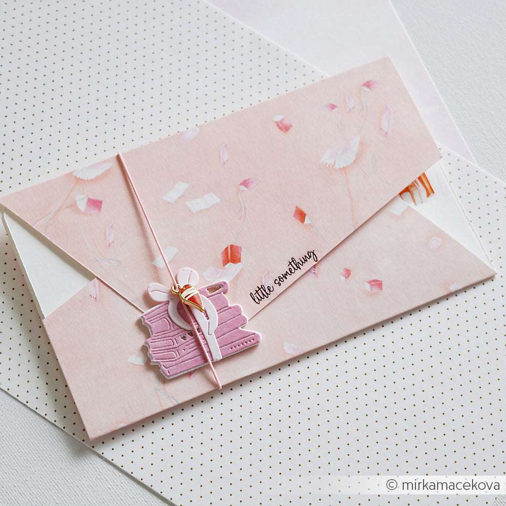 Eleganter rosafarbener Briefumschlag von Alexandra Renke mit einem Kranichmotiv auf Designpapier, verschnürt mit einer Schnur und einem rosafarbenen Anhänger - perfekt für Papierprojekte oder Buchbinderei. Auf weiß gepunktetem Hintergrund für zusätzlichen Charme.