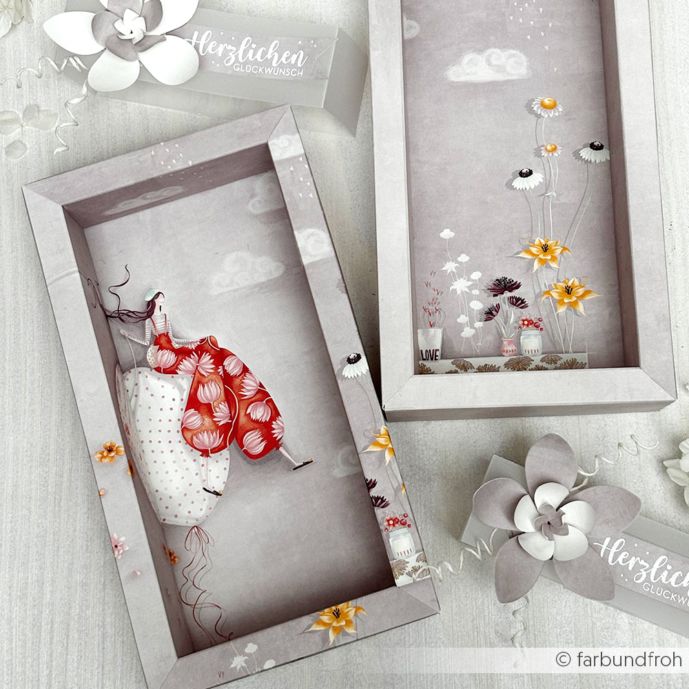 Rechteckige Schachteln von Alexandra Renke mit floralen Motiven, ideal für Designpapier oder Grußkarten - eine zeigt eine Frau in einem roten Kleid, die auf einem weißen Felsen sitzt.