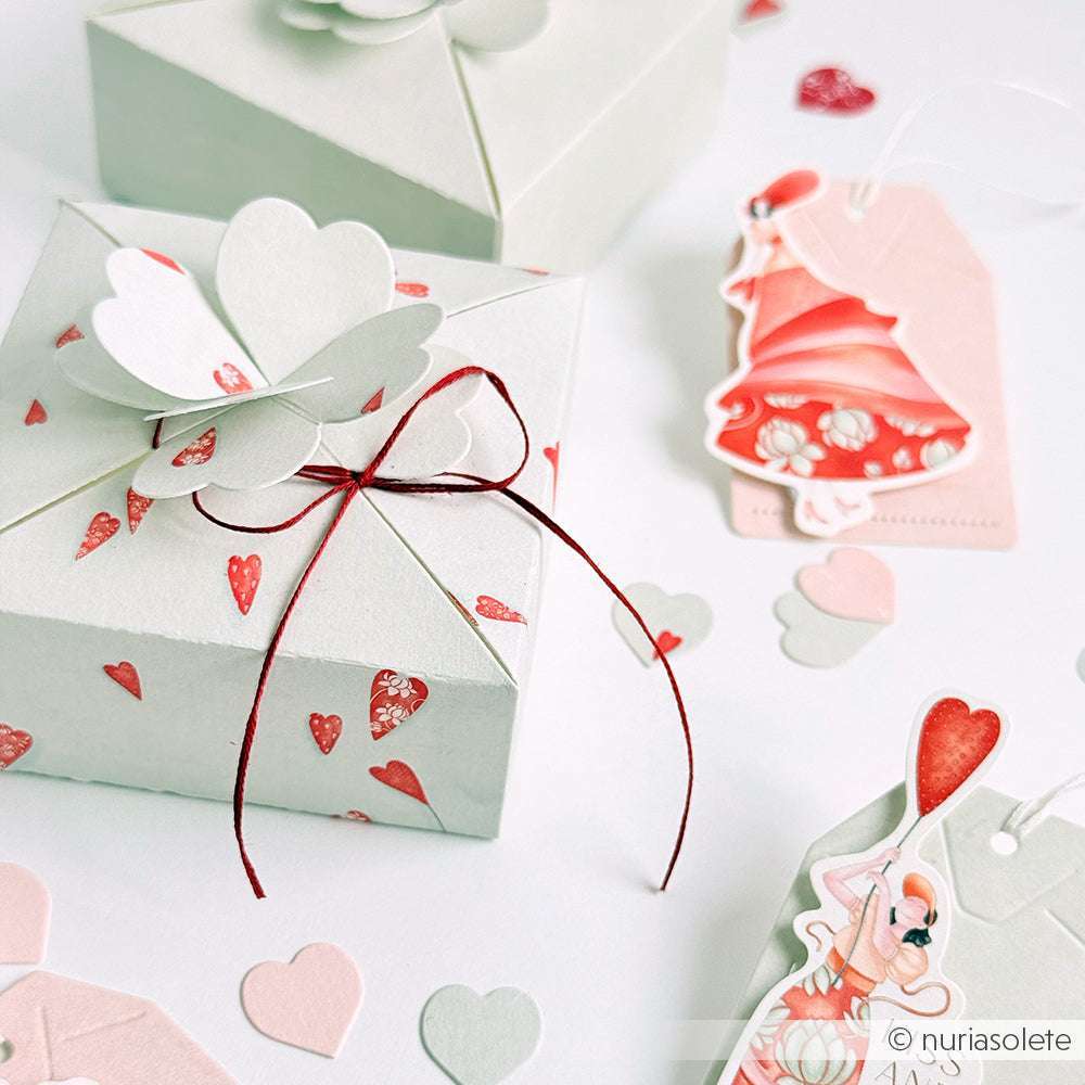 Alexandra Renke Geschenkboxen mit Herzmotiven, roten Schleifen und illustrierten Anhängern von Designpapier verleihen Ihren Papierprojekten Charme, eingebettet in Herzkonfetti auf weißem Hintergrund.