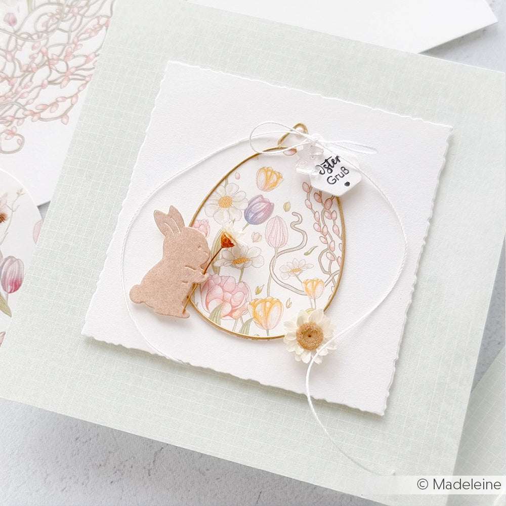 Handgefertigte Karte von Alexandra Renke mit einem Hasen, pastellfarbenen Blumenmustern und zarten Details mit einem kleinen Anhänger - ideal für Papierprojekte oder zum Präsentieren von besonderem Designpapier.