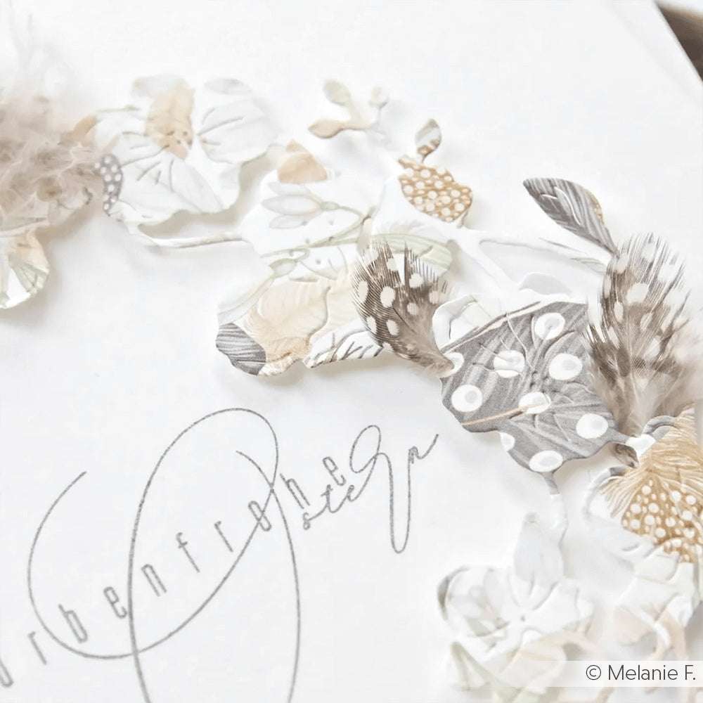 Zarte Papierblumen und Federn aus der Kollektion Alexandra Renke Federkranz Braun-Beige zieren eine weiße Karte mit eleganter Schreibschrift - die perfekte Inspiration für Ihre Papierprojekte und Designpapier-Kreationen.