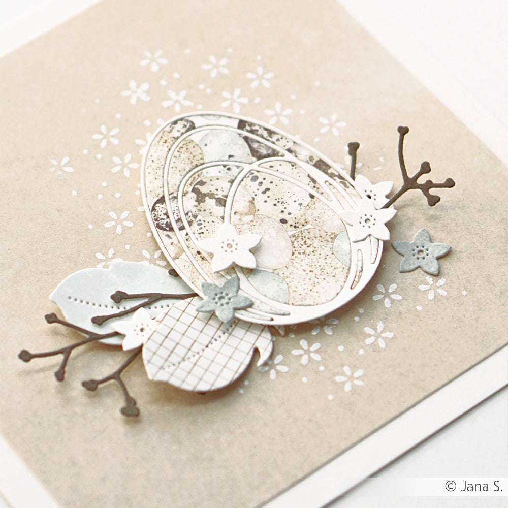 Eine handgefertigte Osterkarte von Alexandra Renke, inspiriert von Eierkranz Blau-Creme, mit geschichteten Eiern, Zweigen und Blumen in sanften Neutraltönen auf Beige mit exquisitem Designpapier.