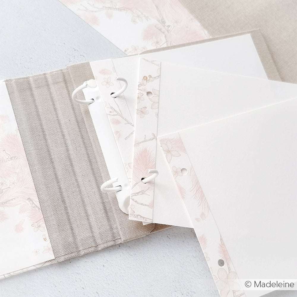 Offener Ordner von Alexandra Renke mit dekorativem, floralem Designpapier mit Feder-Veilchen-Kranz-Motiven und Blankoblättern - perfekt zur Inspiration für Ihre Papierprojekte auf hellem Untergrund.