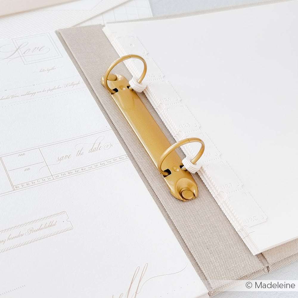 Offener beiger Ringordner mit weißem Papier und Dokumenten von Alexandra Renke - ideal für Designpapier oder Papierprojekte - auf einer hellen Fläche, von oben betrachtet.