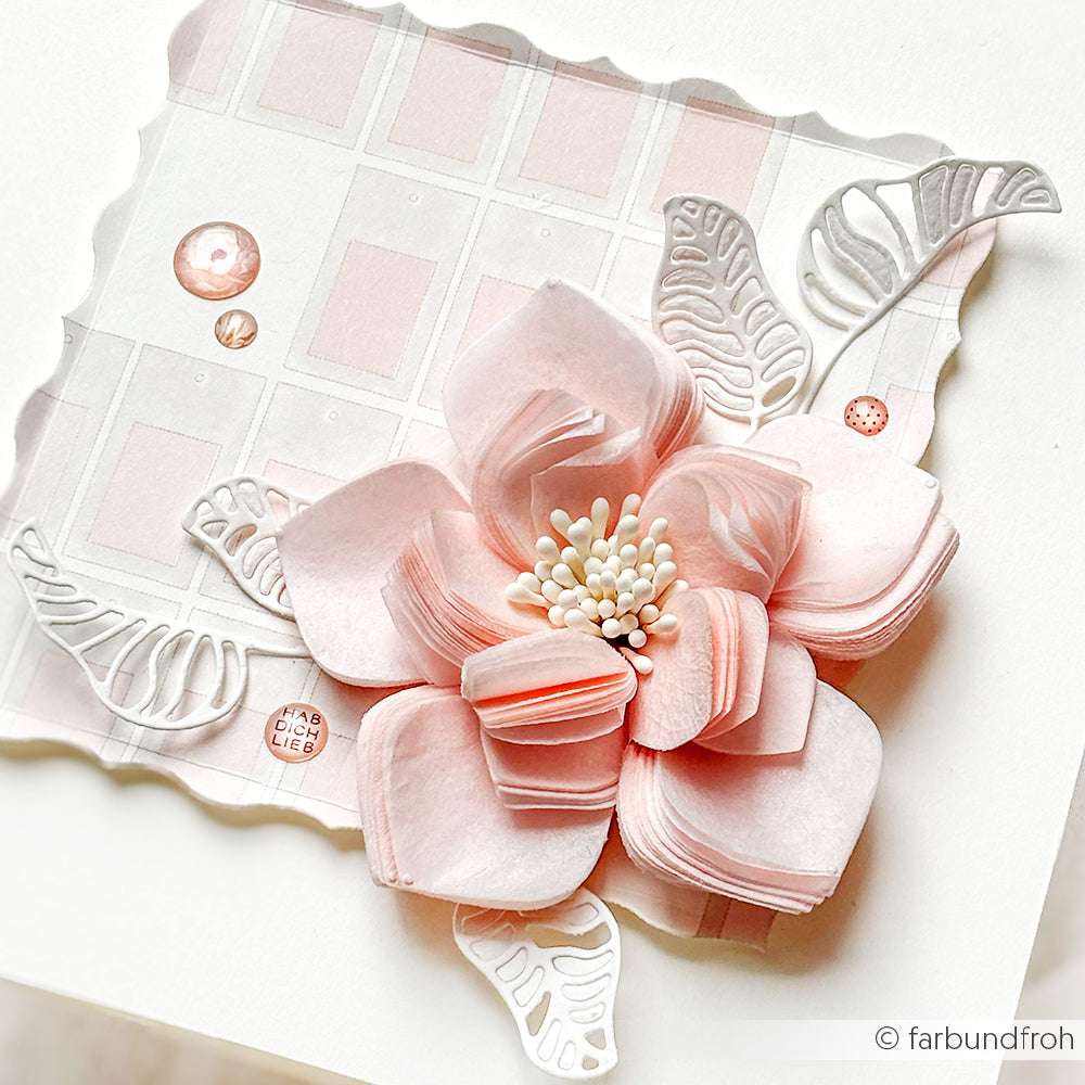 Diese handgefertigte Karte von Alexandra Renke zeigt eine große rosa Farbkarten-Anemone, weiße Blätter und Perlenakzente auf elegantem Designpapier - perfekt für Ihr nächstes Papierprojekt.