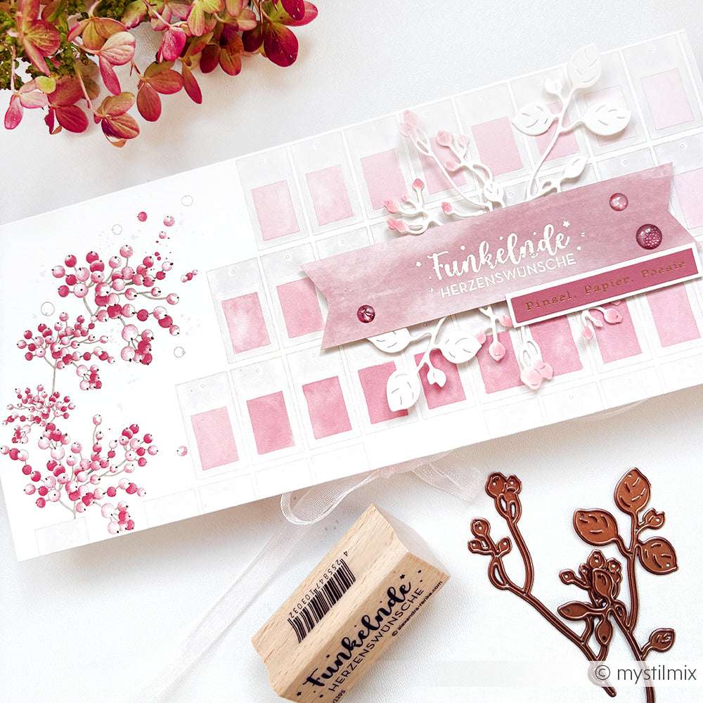 Handgefertigte Karte mit rosa und weißem Blumenthema und deutschem Text, hergestellt mit Alexandra Renke Designpapier & Farbkarten Beerenzweig, neben Stempeln und Metallstempeln gezeigt. Perfekt für Papierprojekte und kreative Inspiration.