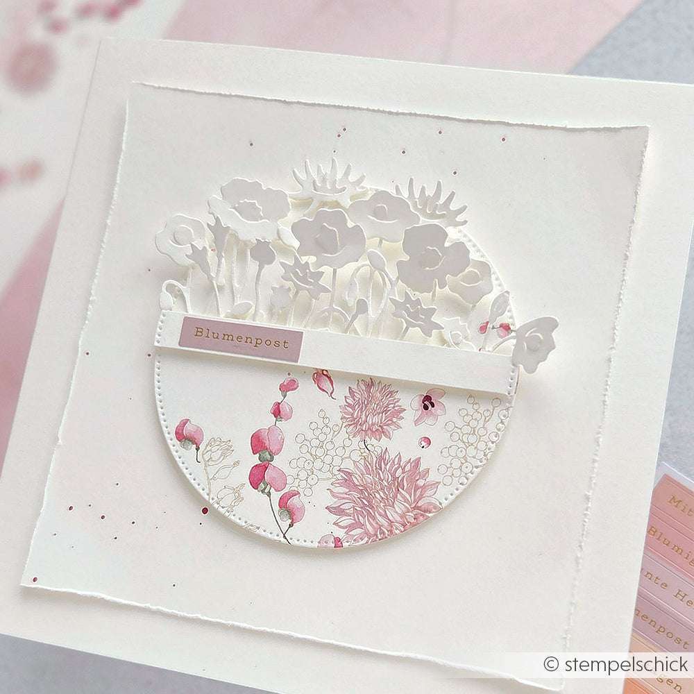 Handgefertigte Alexandra Renke Karte mit floralen Ausschnitten und rosa Dahlien, beschriftet mit Blumenpost-perfekt für Papierprojekte oder als kreative Blütenpracht Dahlienkranz mit schönen Designpapier-Akzenten.