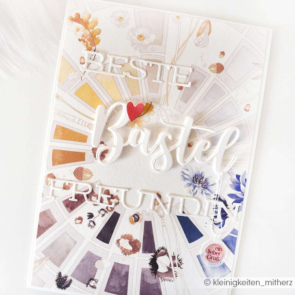 Handgemachte Karte von Alexandra Renke mit "Beste Bastelfreundin" in Weiß, dekorativen Blumen und bunten Aquarelltupfern - ideal für Papierprojekte und mit liebevoll ausgewähltem Designerpapier gestaltet.