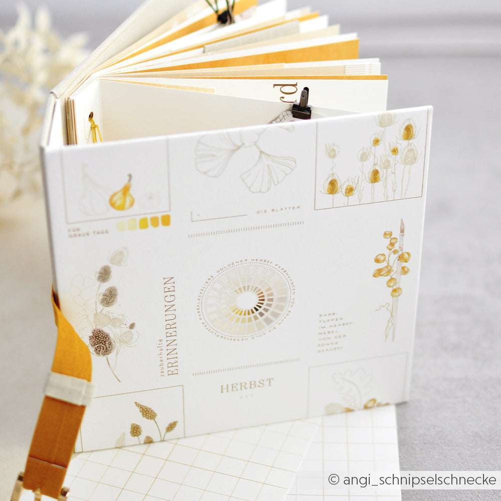 Ein aufgeschlagenes Alexandra Renke Buch mit botanischen Illustrationen und gelben Akzenten steht aufrecht auf einem neutralen Hintergrund - ideal für Papierprojekte oder passend zu unserem Kärtchenbogen Gelb & Ocker.