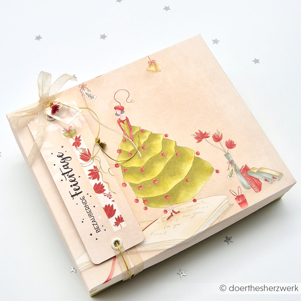 Quadratische zartrosa Geschenkbox von Alexandra Renke mit einer festlichen Designpapier-Weihnachts-Illustration und einem "Besinnliche Feiertage"-Bandanhänger - ideal für Papierprojekte oder Buchbinderei-Geschenke.