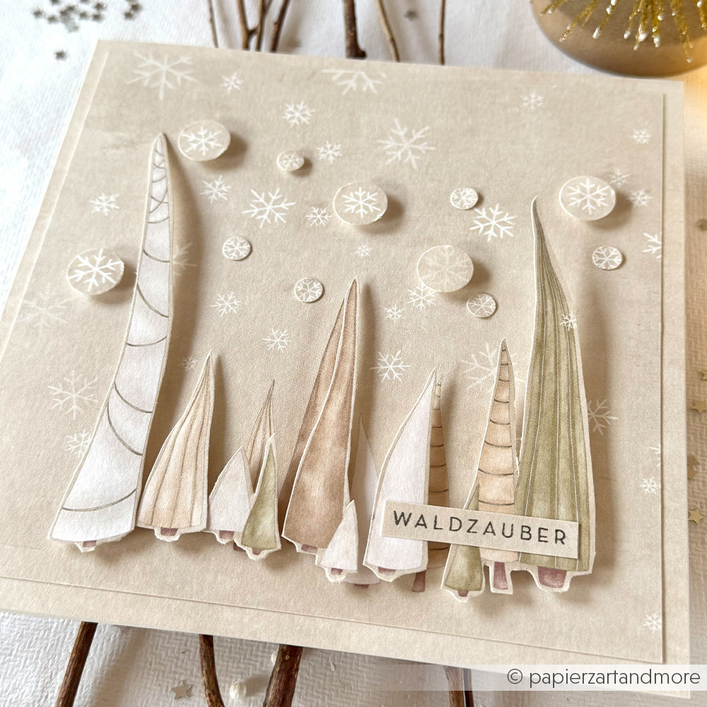 Handgemachte Karte von Alexandra Renke mit 3D-Papierbäumen, Schneeflocken und "Waldzauber" auf beigem Hintergrund, hergestellt aus hochwertigem Designpapier.