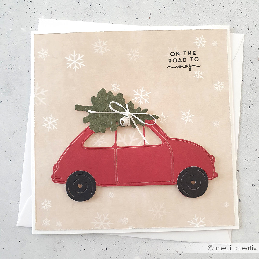 Handgemachte Alexandra Renke Karte mit rotem Auto und Weihnachtsbaum, "On the road to xmas" Text, und festlichem Designpapier Weihnachts Figurinen für einen zauberhaften Winterwaldzauber-perfekt für winterliche Papierprojekte.