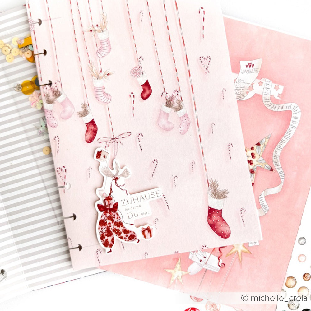 Rosafarbene Scrapbook-Seiten von Alexandra Renke mit hängenden Strümpfen, Fäustlingen, Zuckerstangenhimmel und festlichen Designpapier-Verzierungen zum Thema Weihnachten.